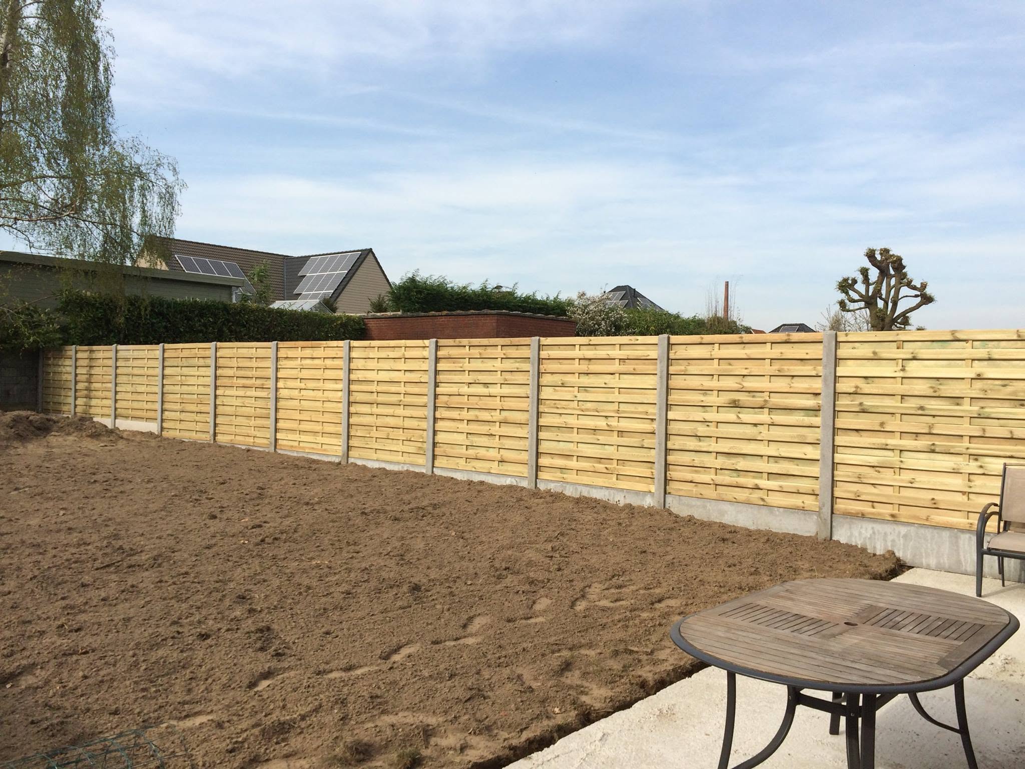 Tuinafsluiting met houten panelen en nieuwe gazon