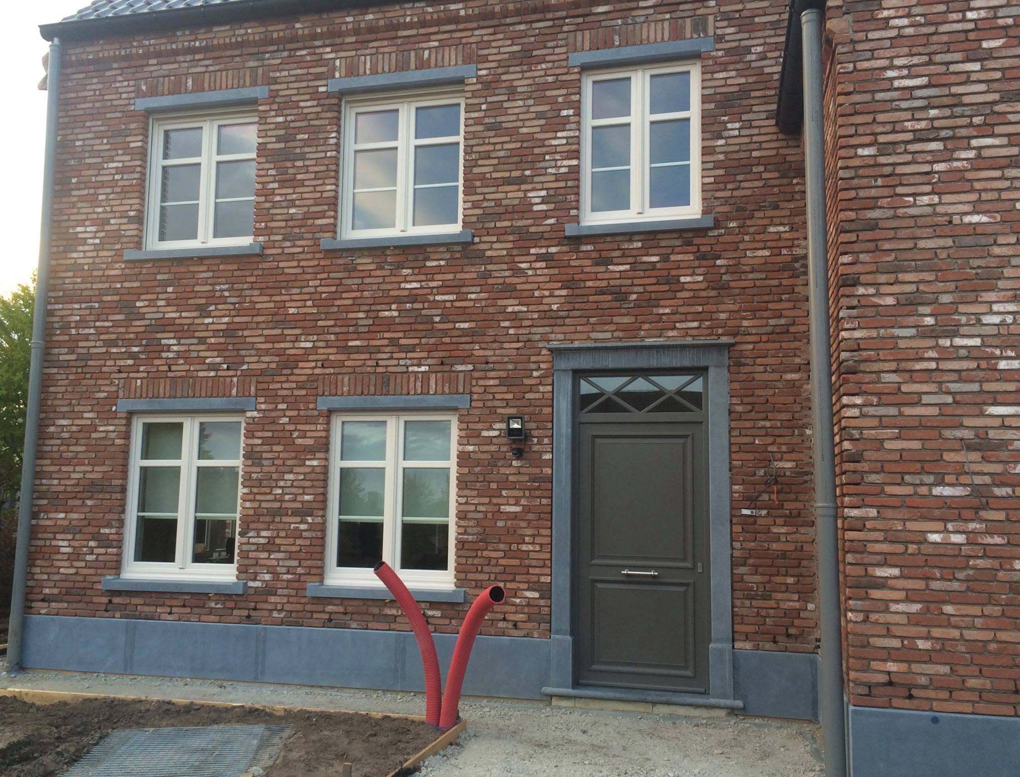 Gevel in gevelsteen met blauwe hardsteen plint