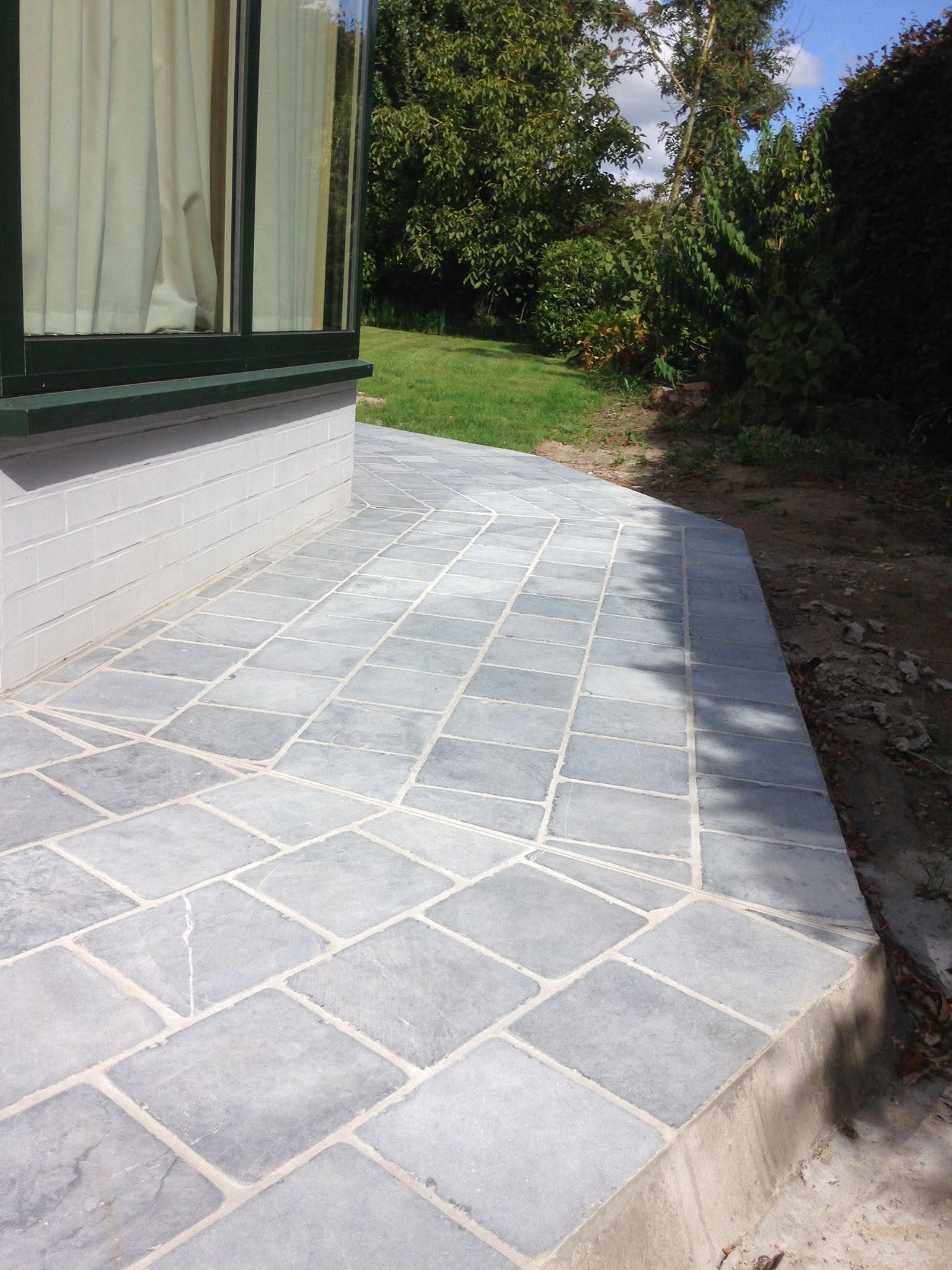 Terras in natuursteen langs de woning